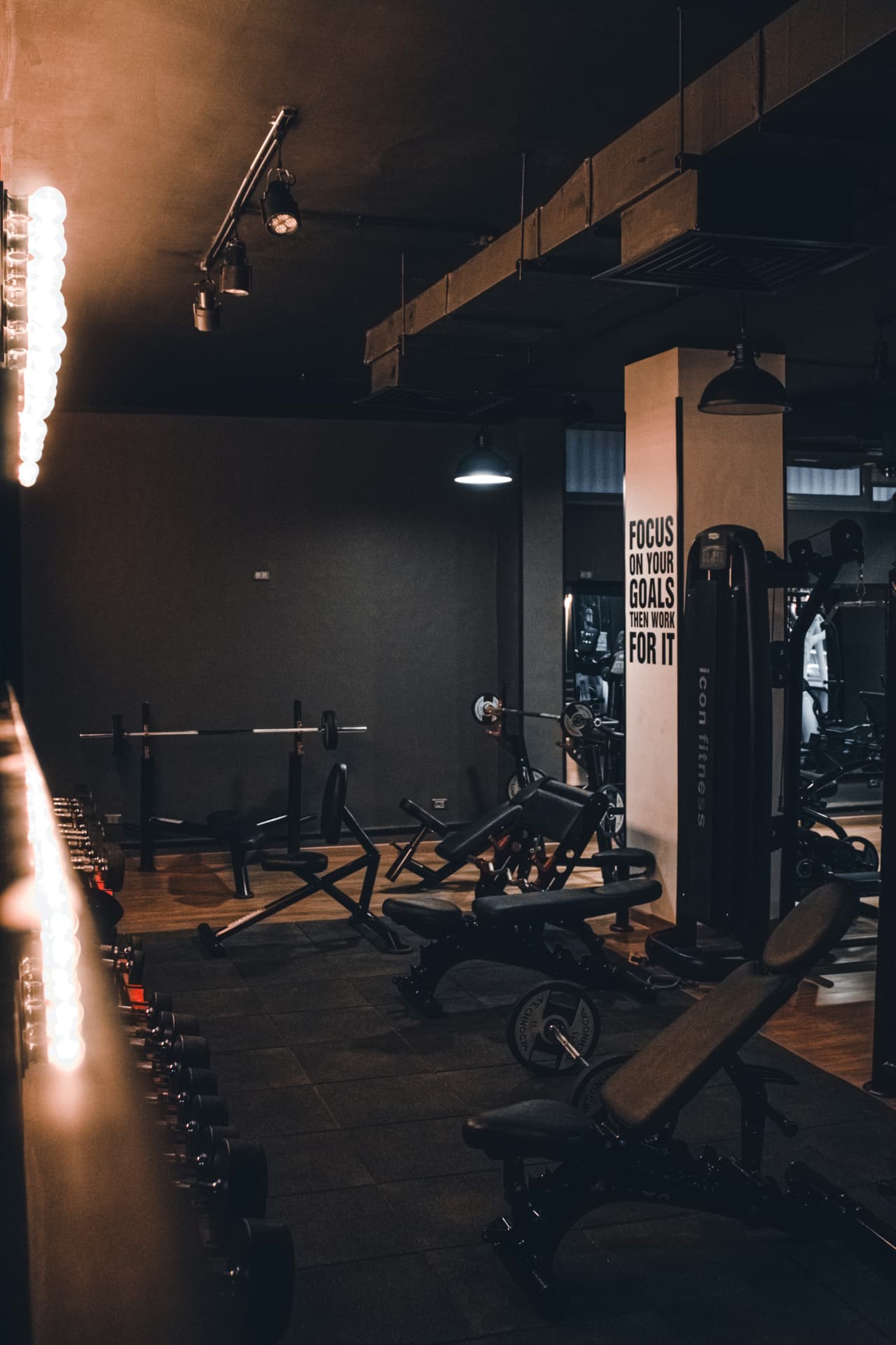 Quiet gym floor with racks, benches and dumbbells before opening